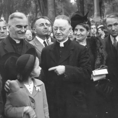 Lionel Groulx (au centre), Blaise Pleau, prêtre (à sa gauche) et d'autres personnes non identifiées, lors d'une cérémonie soulignant le dixième anniversaire de la mort de Jeanne Lajoie, au cimetière Notre-Dame-des-Neiges, en 1940.