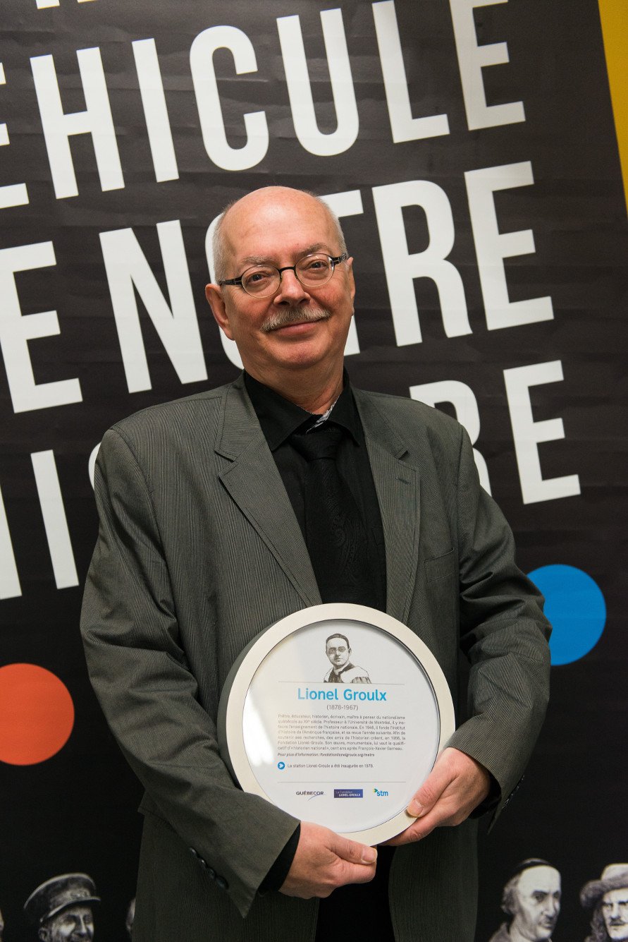 Pierre Graveline, directeur général de la Fondation Lionel-Groulx, portant une plaque commémorative à l'effigie du chanoine.